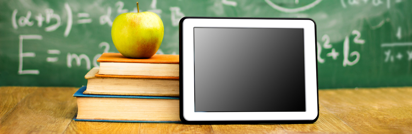 Heroimage green apple on books next to tablet